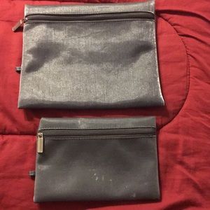 Woman’s grey clutch or cosmetic bags.